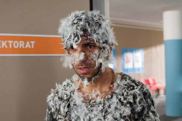 A man covered in feathers in a scene from "Fack ju Göhte".