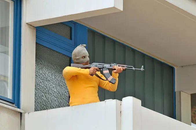 München 72 - Das Attentat: Masked gunman aiming rifle on balcony