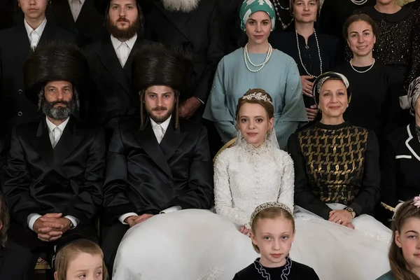 A wedding group photo from Unorthodox, featuring people in traditional Orthodox Jewish attire.