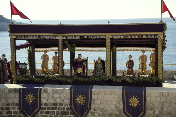 A royal pavilion by the sea in "Vikings: Valhalla", with figures of authority seated.